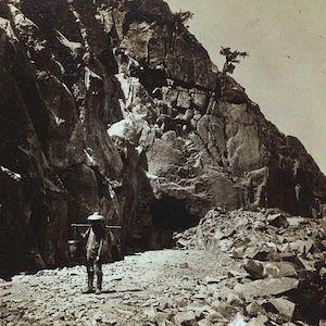Photo of a man carrying some debris from a tunnel